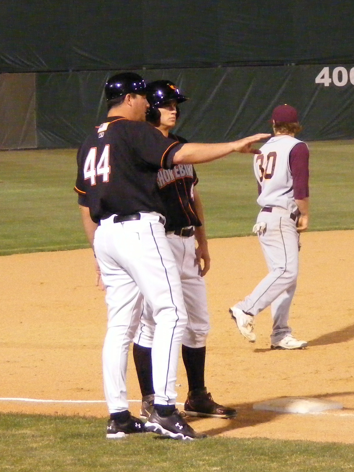 Standing at third, Mike Planeta consults with manager Ryan Minor. Photo by Kimberley Corkran.
